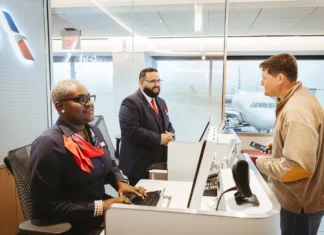 American Airlines app adds hotel and meal vouchers for delays a group of people at a desk. American Airlines app update. {Tech} for Travel. https://techfortravel.co.uk