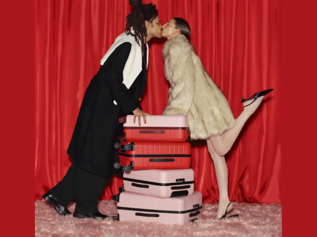 a man and woman kissing on top of luggage. Away Limited Edition Bigger Carry-on. {Tech} for Travel. https://techfortravel.co.uk