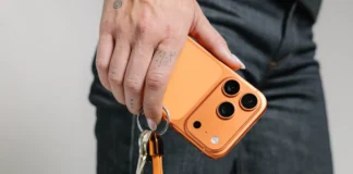 Nomad ChargeKey completes the look for Cosmic Orange iPhone owners a person holding a phone with keys. Nomad ChargeKey v2 Stellar Orange. {Tech} for Travel. https://techfortravel.co.uk