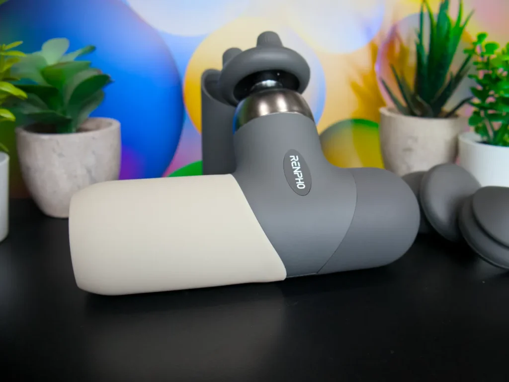 a grey and white device on a table. RENPHO Mini Thermal Massage Gun review. {Tech} for Travel. https://techfortravel.co.uk