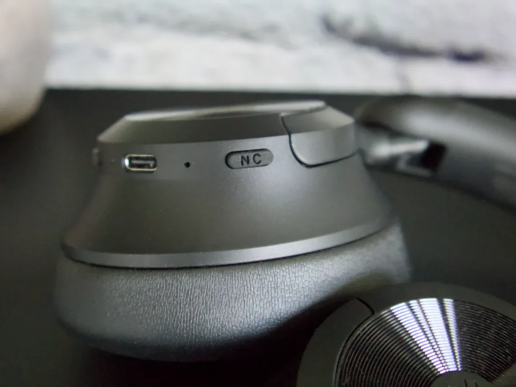 a black round object with a round button. OneOdio Focus A1 Pro Review. {Tech} for Travel. https://techfortravel.co.uk